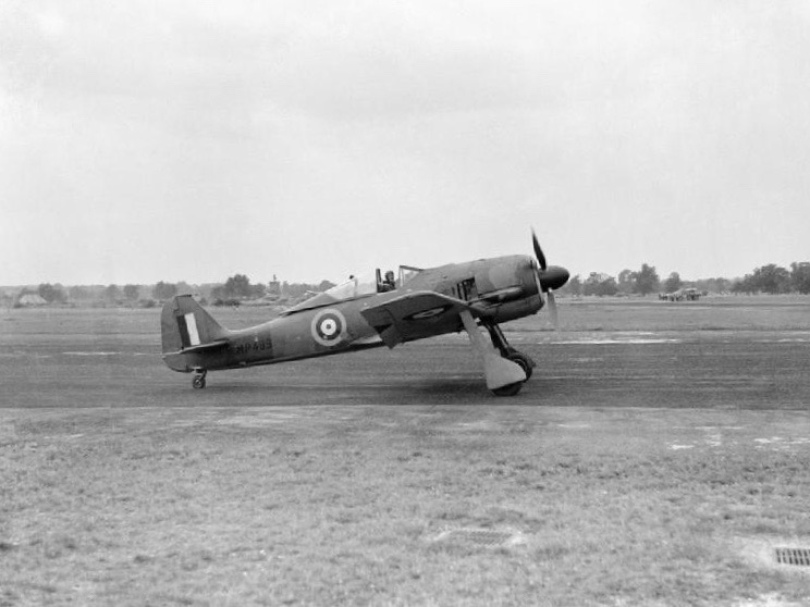 Squadron Leader Hugh J. Wilson, AFC and Bar, in teh cocpit of a captured Focke-Wulf Fw 190A3, Werke Number 313, in RAF markings as MP499. (Royal Air Force)